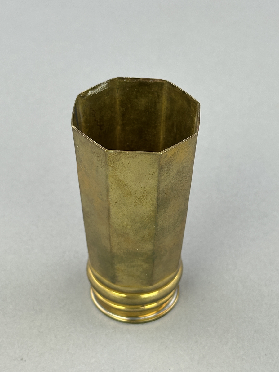 Vas av mässing med rund botten och åttkantig överdel.