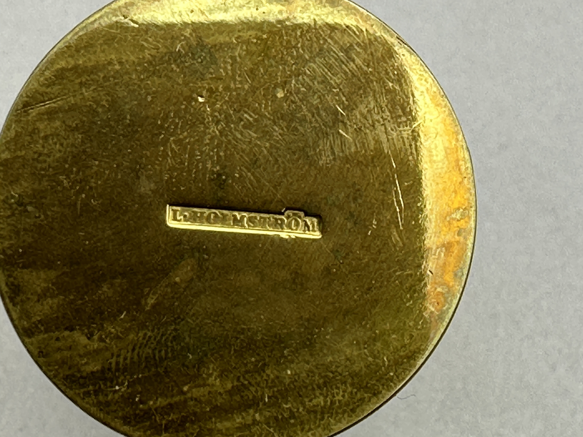 Vas av mässing med rund botten och åttkantig överdel.