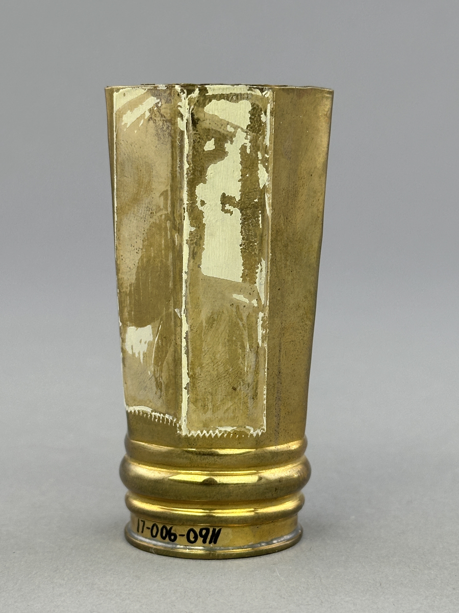 Vas av mässing med rund botten och åttkantig överdel.