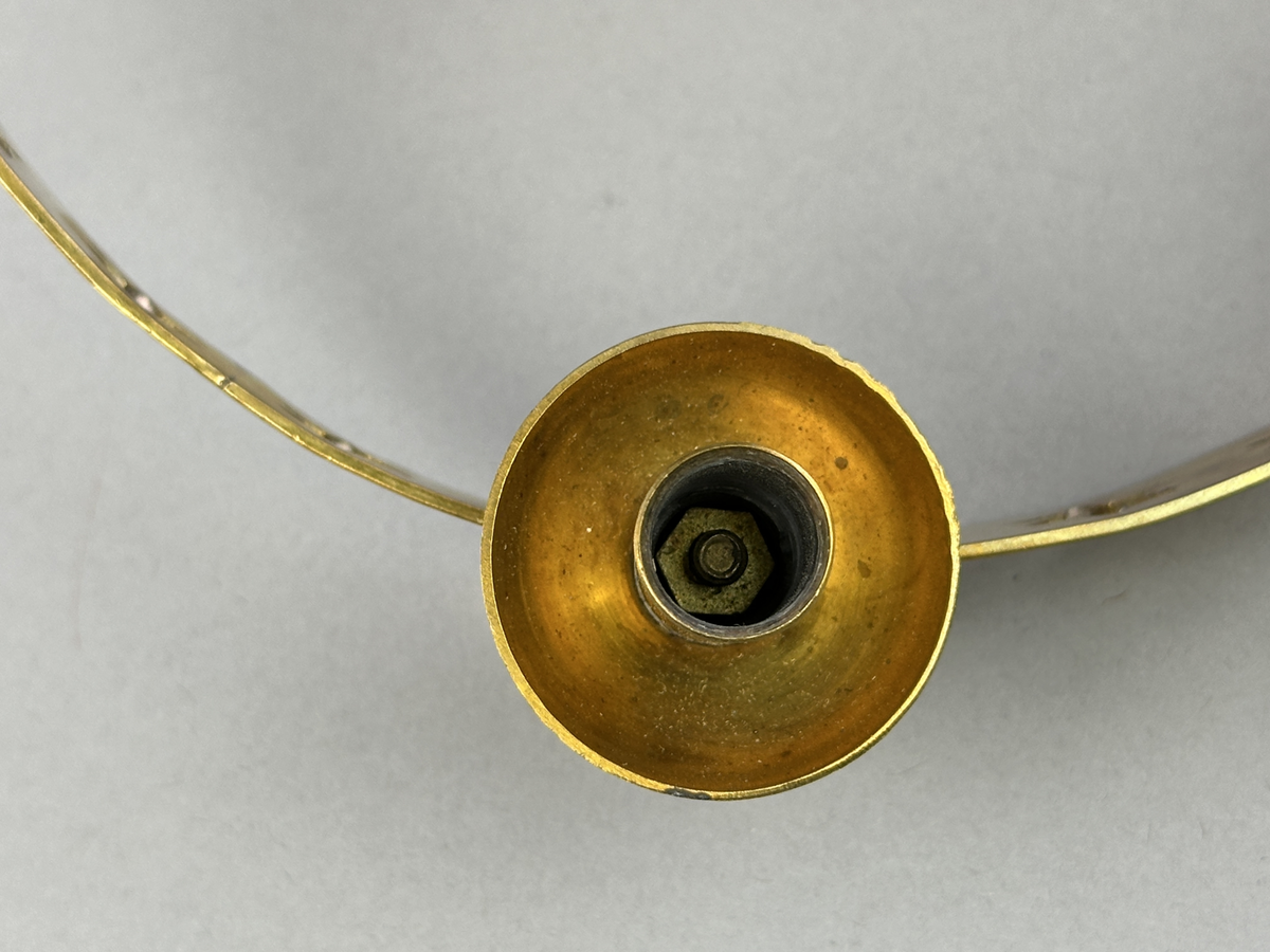 Ljusstake, "Luciakrona" för sex små julgransljus, gjord av mässingband med utstansat stjärnmönster. Ljushållarna är fastlödda på bandets högkant.