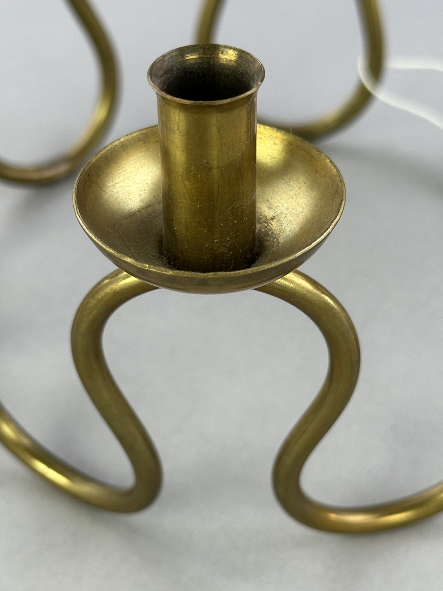 Ljusstake, "Luciakrona" för sju små stearinljus, gjord av mässingtråd som böjts i mjuk vågform. Högst upp på varje böj sitter en ljushållare fastnitad.