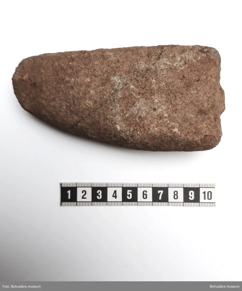 Yxa, fyrsidig, ev. håleggad. Skadad, avslaget eggparti.