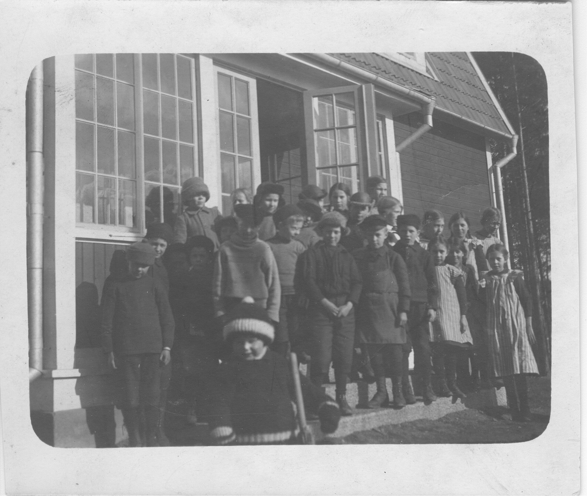 Rudkälla skola med skolans elever samlade på trappan..  Pojken i första ledet som är närmast flickorna är Ellert Carlsson född 1909 vid Vartå Bilden är tagen mellan 1914 och 1916 då familjen Carlsson bodde vid Björkvik.

