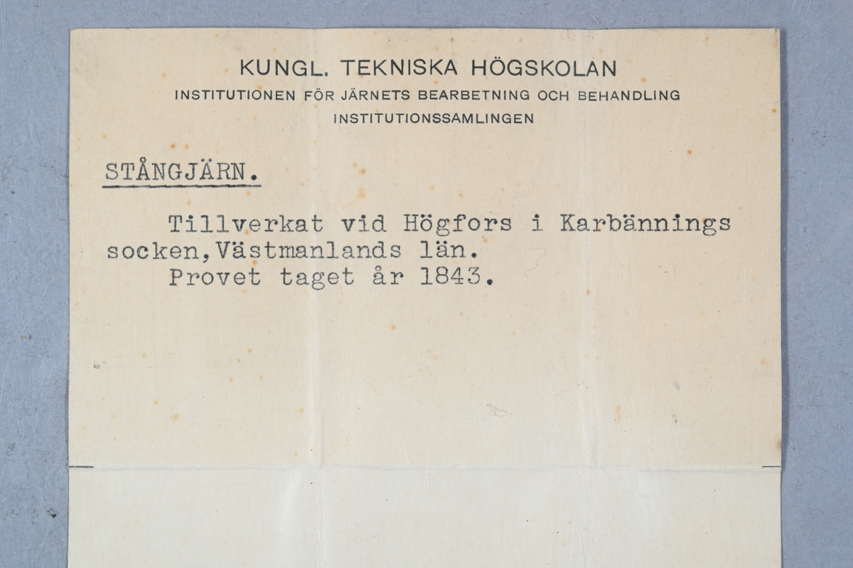Två prov på stångjärn. Ena provet märkt med Högfors bruks stämpel. Tillhörande lapp med notering: "Stångjärn. Tillverkat vid Högfors i Karbännings socken, Västmanlands län. Provet taget år 1843."