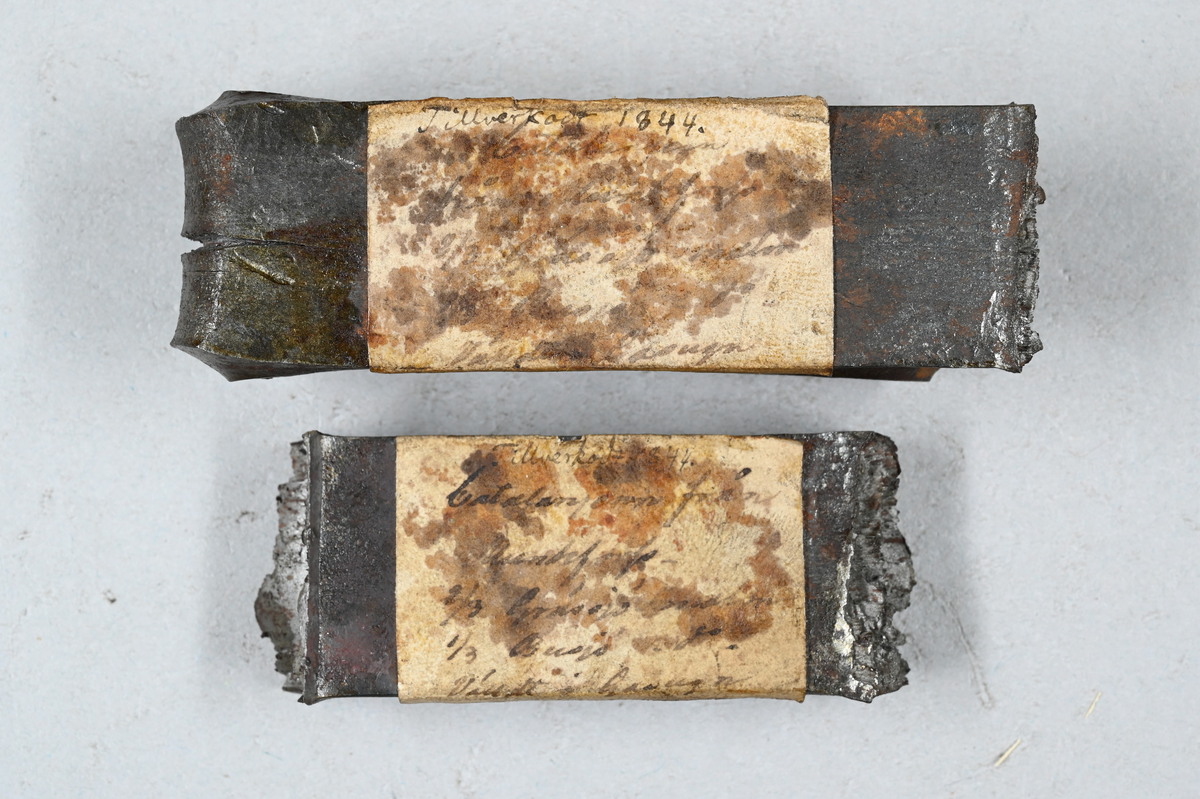 Två prover av stångjärn. Båda proverna märkta med påklistrad lapp med samma notering: "Tillverkadt 1844. Catalanjern från Munkfors. 2/3 Gräs...?, 1/3 Busjs (?), Välldt i gasugn." Tillhörande lapp med notering: "Stångjärn. Catalanjärn från Munkfors. Vällt i gasugn. Provet taget år 1844."