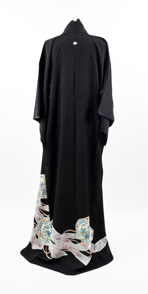 Kimono i svart silke med et kontinuerlig mønster plassert diagonalt på den nedre delen av plagget. Motivet er orientalsk, blomsterdekorert porselen med konturer fremhevet av påsydde gull-lisser, samt hvite bånd med rosa blomster og flettede snorer imellom porselenet. Kimonoen har små ornamenter (komon) plassert i nakken, på skuldre og ermer.