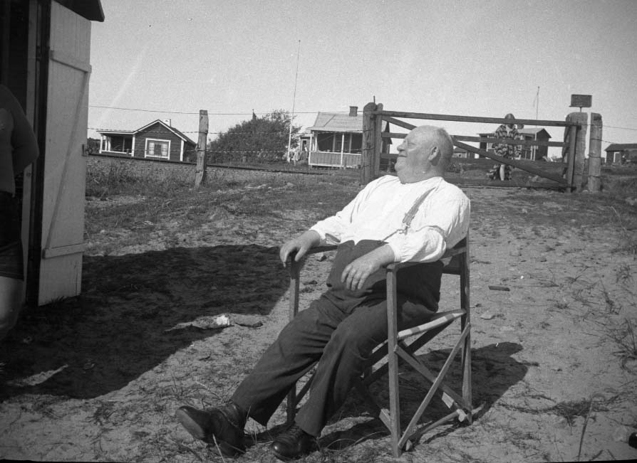 Fyra bilder av en man med vänner i sommarstuga och på stranden, troligen i Apelviken. Möjligen står det "Kurri" på ett av negativfacken. Meddela oss gärna om du har information om mannen!