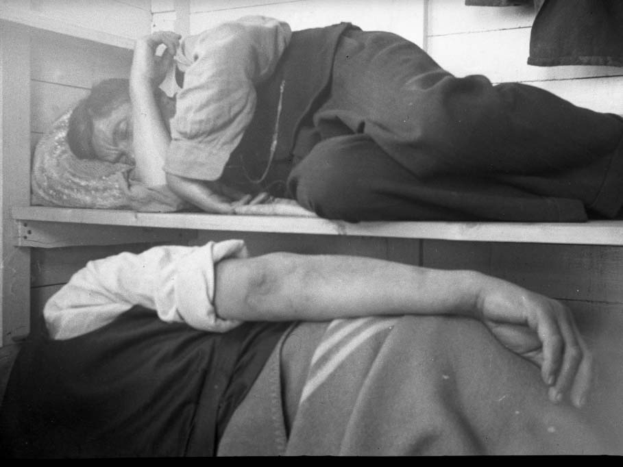 Fyra bilder av en man med vänner i sommarstuga och på stranden, troligen i Apelviken. Möjligen står det "Kurri" på ett av negativfacken. Meddela oss gärna om du har information om mannen!