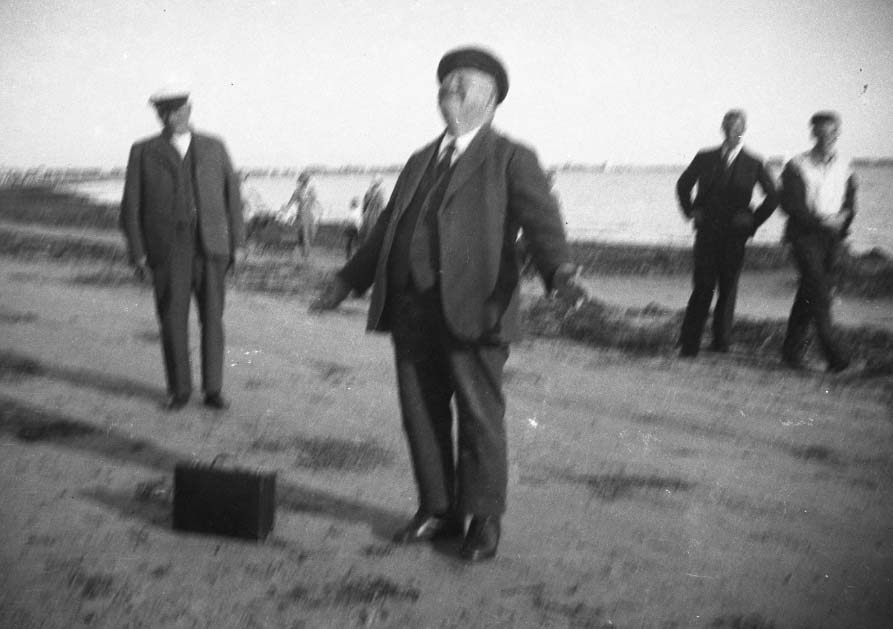 Fyra bilder av en man med vänner i sommarstuga och på stranden, troligen i Apelviken. Möjligen står det "Kurri" på ett av negativfacken. Meddela oss gärna om du har information om mannen!