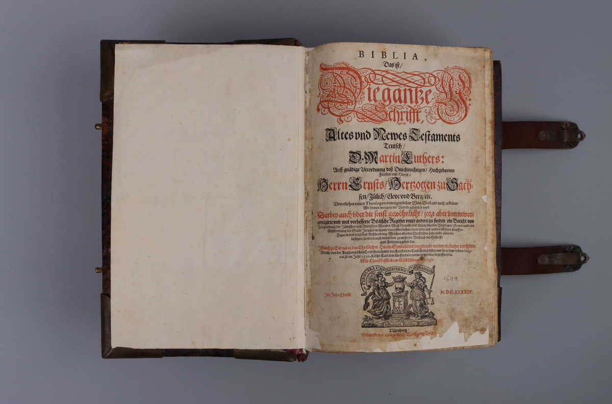 Bibel, marmorerat skinnband med upphöjda bind, dekorerad rygg. På framsida beslag i genombruten mässing med olika apostlar mitt på Moses med stentavlor. Omtag och lås med Karl XII monogram. Bibeln rymmer flertalet planscher och porträtt samt utvik med kartor.