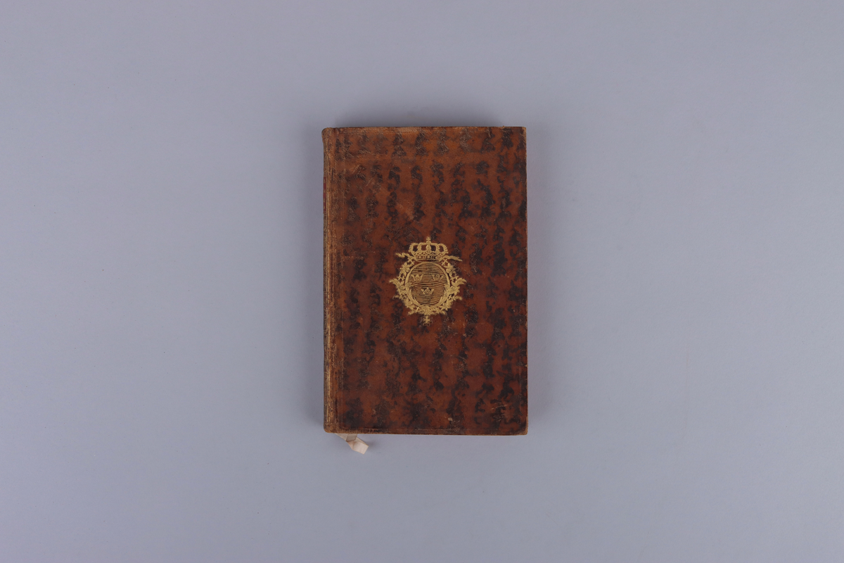 Bok, marmorerad skinnband, med guldornerad rygg, mörkröd titeletikett av glättad papp och röda snitt. På framsida kungligt monogram i guld, Gustav den tredje, På insida av pärm exlibris från Christian Hammer. Titelsida med "Histoire raisonnée des opérations militaires et politiques de la dernière guerre, suivie d'observations sur la révolution qui est arriv´ée dans les mœurs & sur celle qui est sur le point d'arriver dans la constitution d'Angleterre". par M.Joly De St. Valier, Lieutenant - Colonel d´Infanterie, A Liége, Et  fe trouve che les principaux Libiraires de Í´Europe".