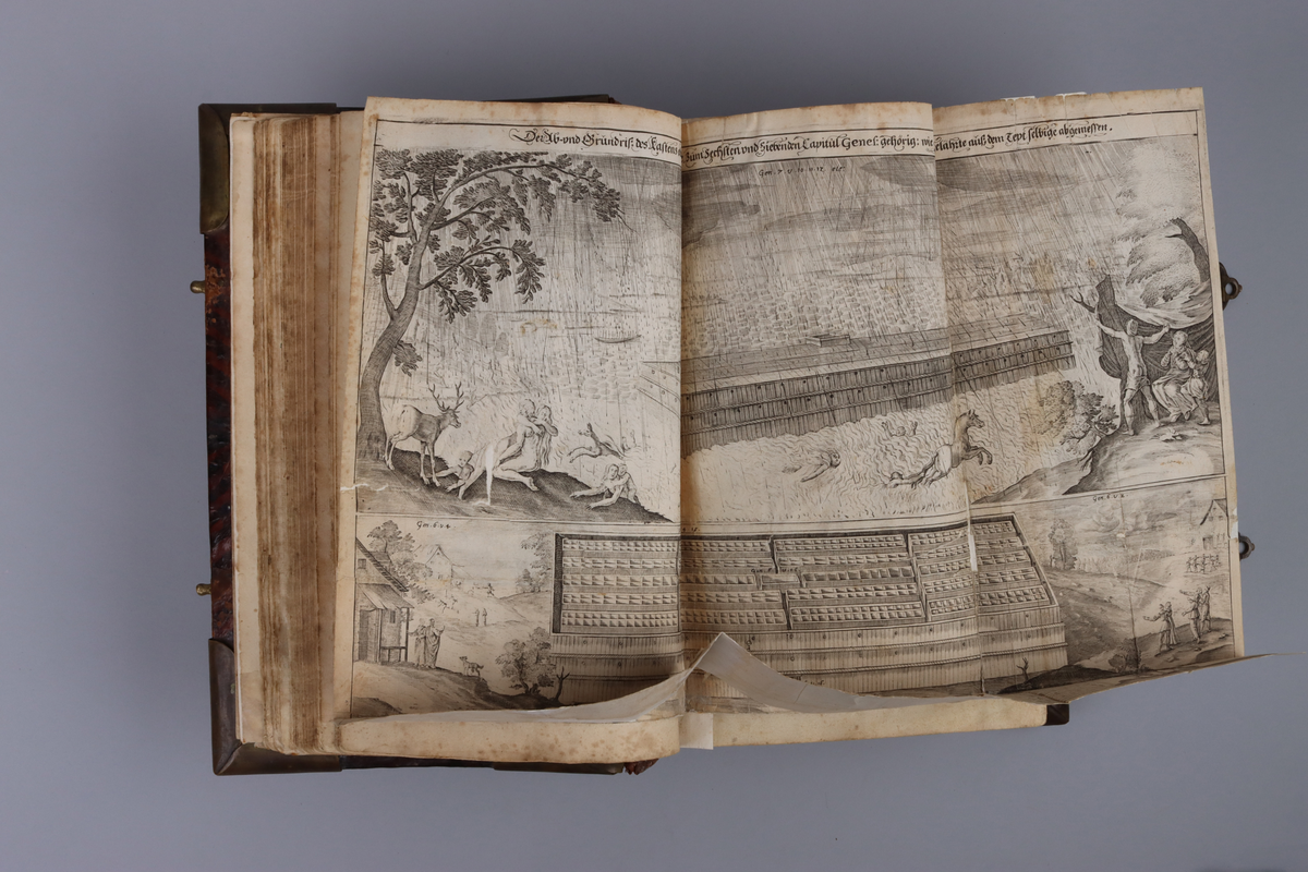 Bibel, marmorerat skinnband med upphöjda bind, dekorerad rygg. På framsida beslag i genombruten mässing med olika apostlar mitt på Moses med stentavlor. Omtag och lås med Karl XII monogram. Bibeln rymmer flertalet planscher och porträtt samt utvik med kartor.
