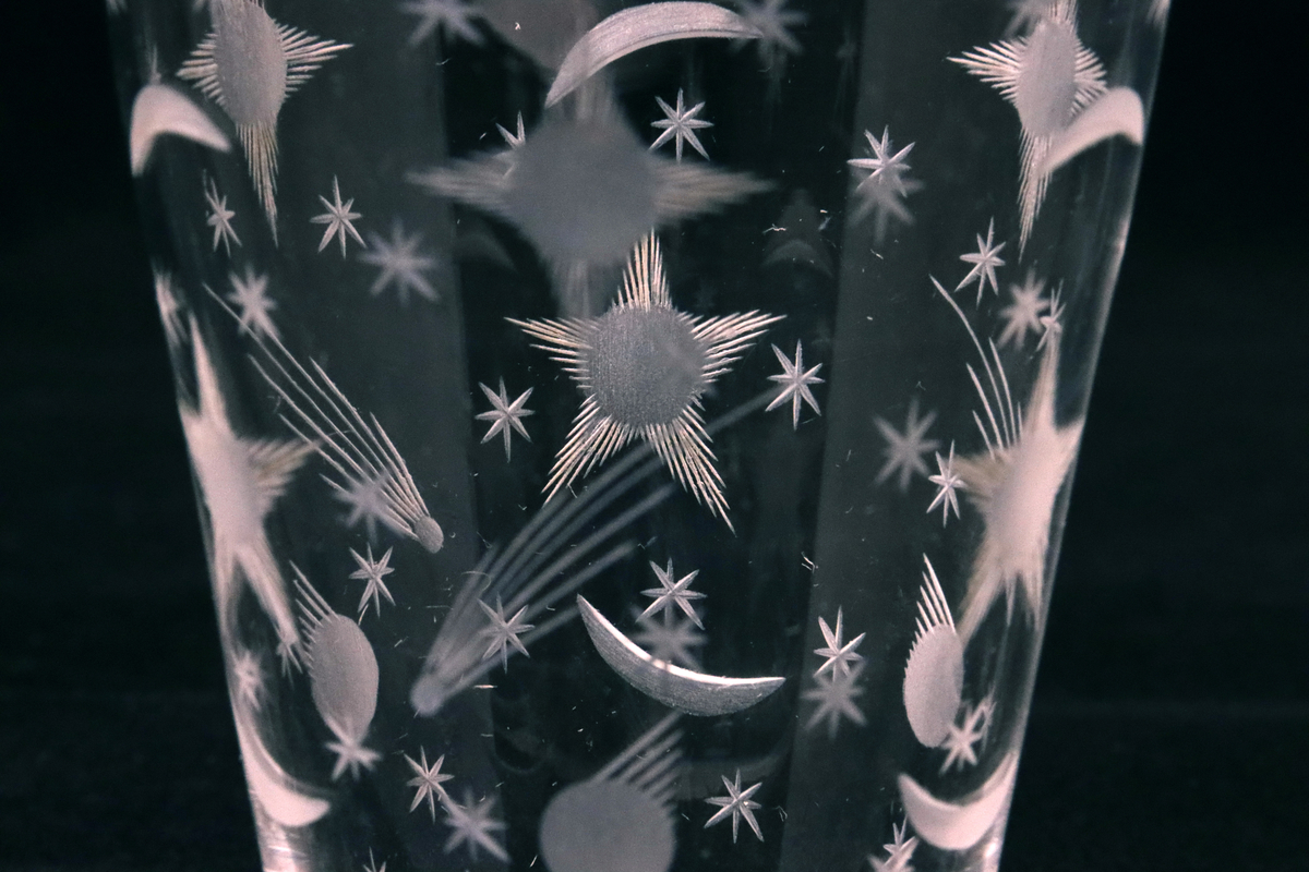 Selterglas med slipat mönster.
Tunt glas som utvidgas mot mynningen. Hela glaset är dekorerat med inslipat mönster i form av större och mindre stjärnor, även stjärnfall.