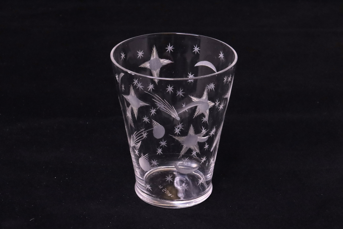 Selterglas med slipat mönster.
Tunt glas som utvidgas mot mynningen. Hela glaset är dekorerat med inslipat mönster i form av större och mindre stjärnor, även stjärnfall.