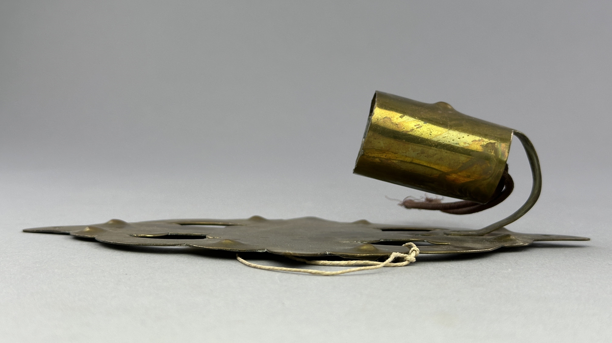 Lampett av mässing för en glödlampa. Lamphållaren är fastnitad.