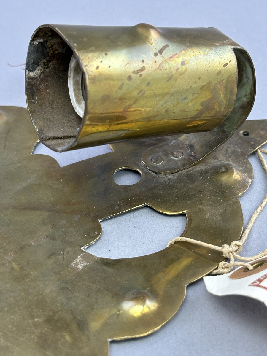 Lampett av mässing för en glödlampa. Lamphållaren är fastnitad.