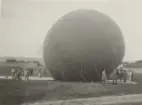 Kapten Yngve Stiernspetz står vid en ballong som fylls med gas. 1930-tal.