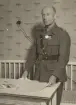 Officer med medaljer står vid skrivbord, expeditionstjänst, uniform m/1939.