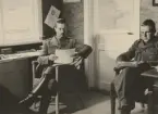 Två infanterister läser papper vid skrivbord, expeditionstjänst, uniform m/1939.