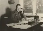 Löjtnant vid artilleriet svarar i telefon vid skrivbord, expeditionstjänst, uniform m/1939.