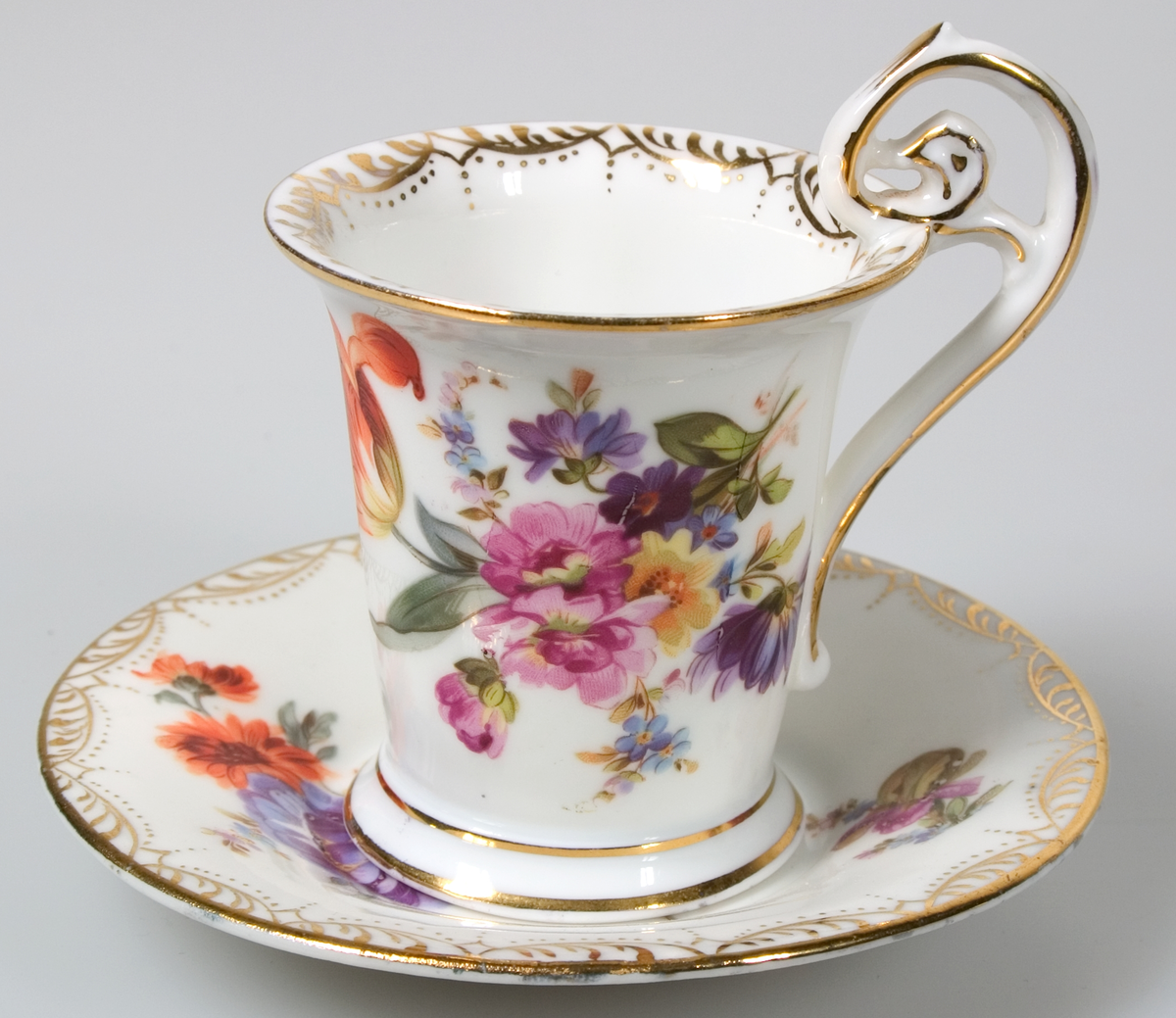 Sex kaffekoppar med fat, av vitt porslin. Guldkantsdekor. Blommålning i olika motiv i rosa, orange, blått, grönt, lila, gult mm. Av märket Meissen.



