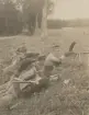 Man med kulsprutegevär hukar i dike med kamrater, uniform m/1910.
