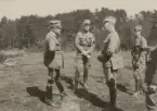 Officerare i uniform m/1923 samtalar på fält.