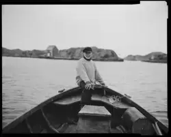 Man in old boat, Røvær [Fotografi]