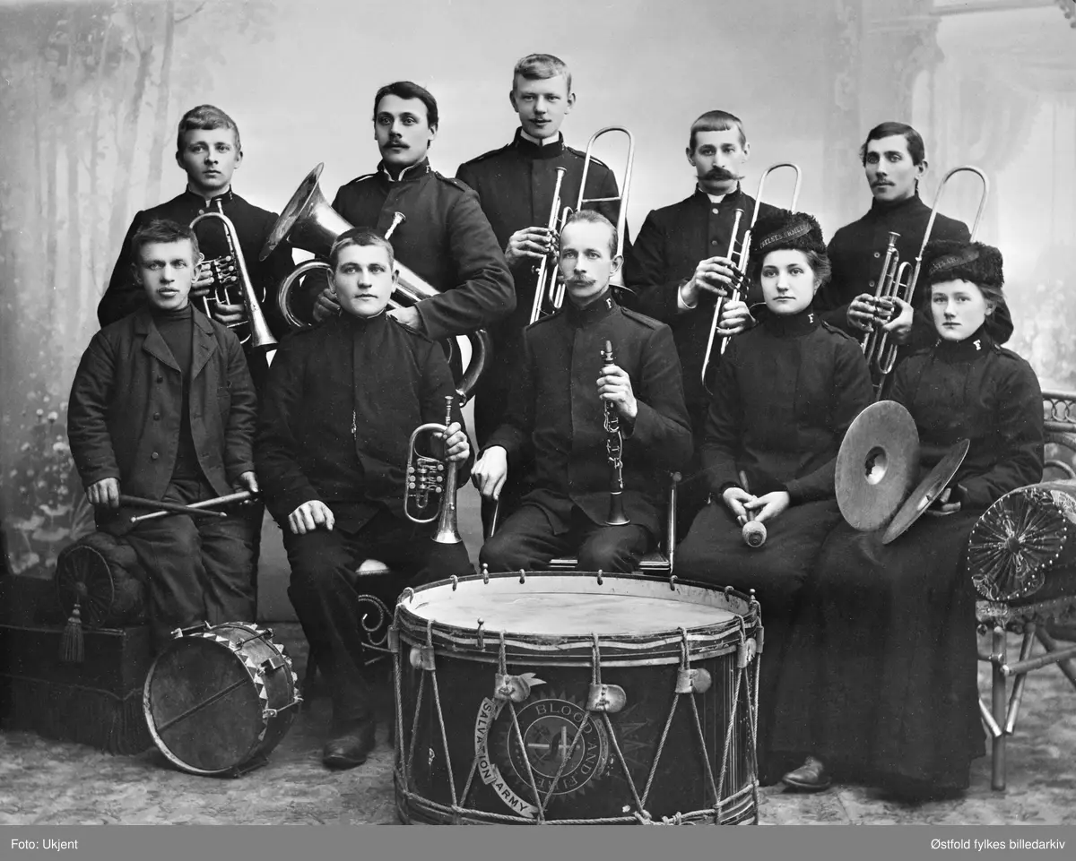 Gruppebilde av Frelsesarmeens hornmusikk i Tistedal 1905. Korpset ble stiftet i 1897. Tekst på stortromma: Salvation Army. Blood and fire.
1. rekke fra venstre: 
Wilhelm Kaspersen, Viktor Andersen, ensein  Tangen, Hilda Østhaug (senere major), Olga Gustavsen.
2. rekke: 
Hans Forsberg, Edvard Edvardsen, Karl Martinsen, Edvind Lettenstrøm, Frithjof Ypperstrøm.

Ensein er tidligere befalsgrad mellom kaptein og adjutant i Frelsesarmeen.