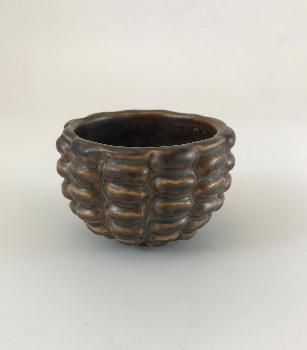 Axel Salto, skål, utförd i s.k. knoppande stil, glaserad i s.k. Sung-glasyr i ljusbrun, svart och grå nyans. Tillverkning: Den Kongelige Porcelainsfabrik, Köpenhamn.