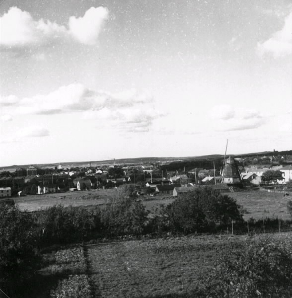 "Vy över Varberg tagen från Hästhagabergen. Vattentornet (ca 1897-1954) skymtar vid horisonten och 'Börjessonska' kvarnen å kv Ryttaren 16, som ännu står där (2003)."