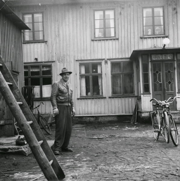 Nils Göran Åsare journalist på Hallands Nyheter (?) som även drev Fastens Café som hotellrörelse. Här på gården till kaféet. Anteckning på baksidan, "Med hälsning från Eric Johansson, Feb. 1952."