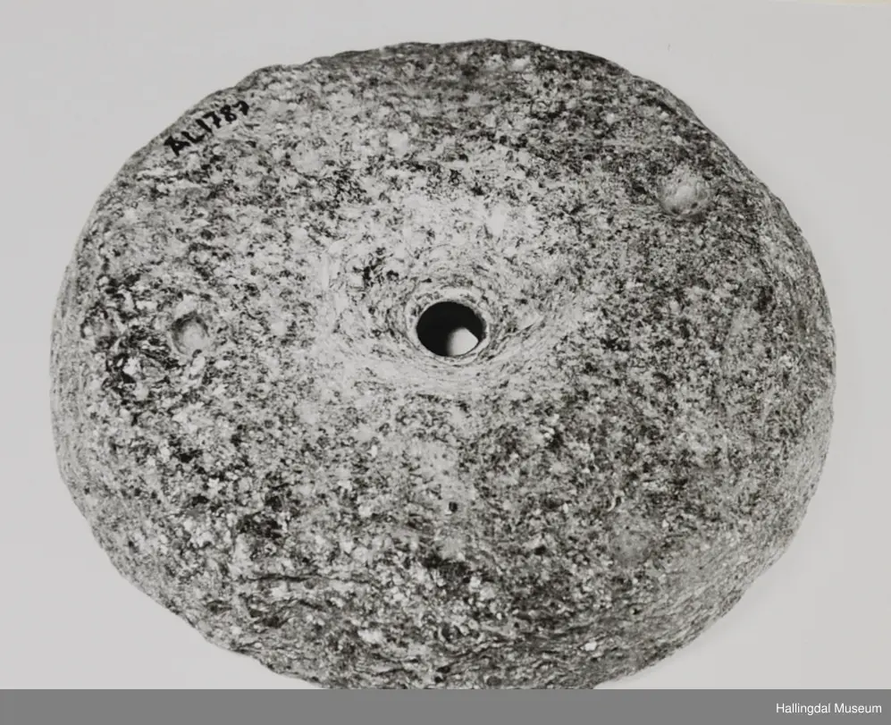 Rund stein med rundt hol i midten.