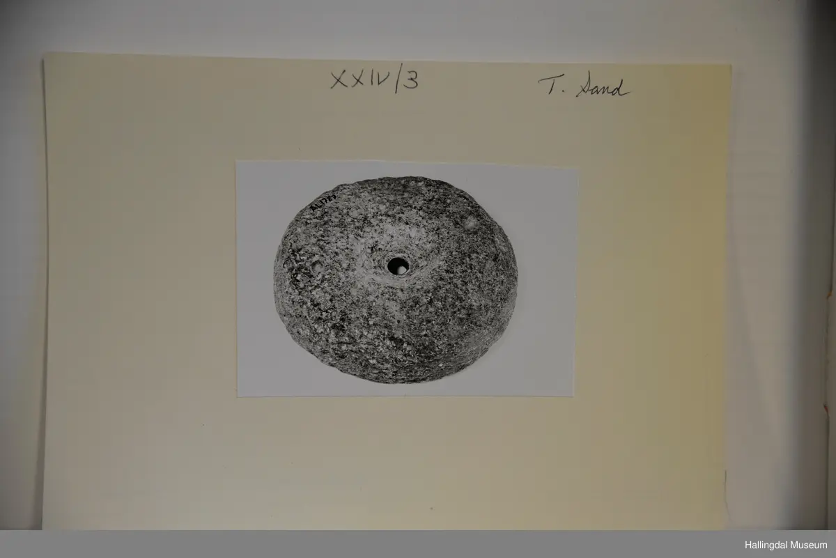 Rund stein med rundt hol i midten.