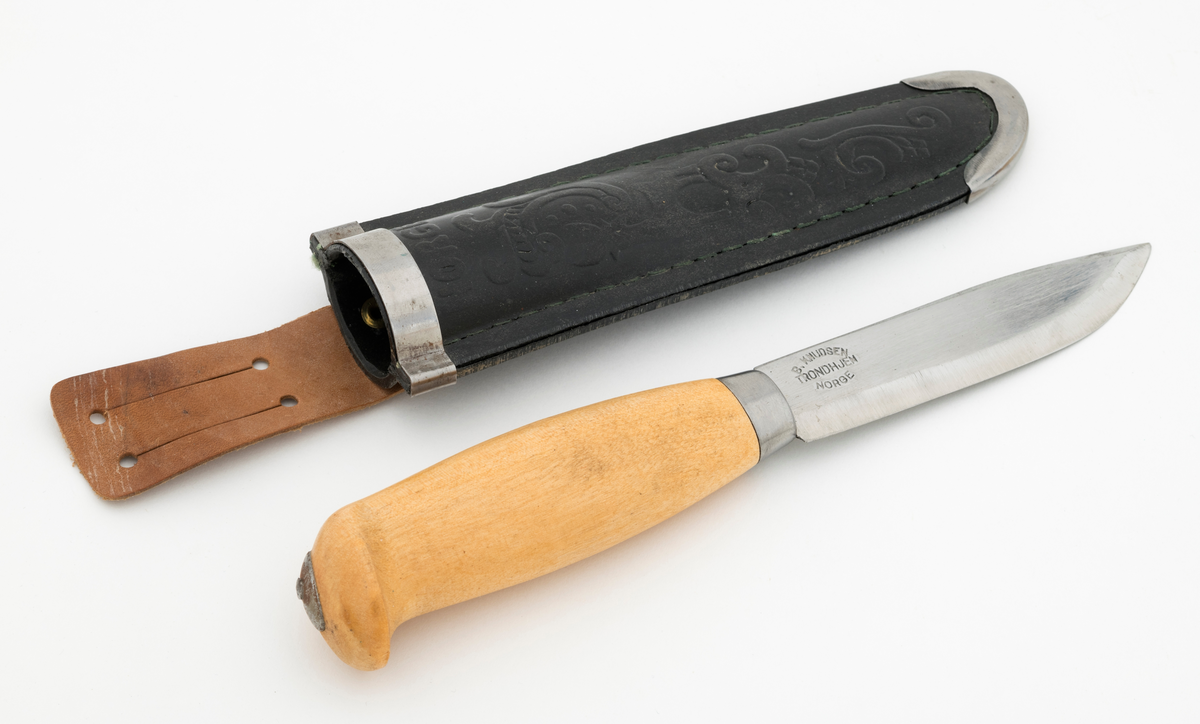 Tollekniv med slire. Denne kniven er fabrikkprodsert, og bladet minner om de populære svenske Mora-knivene, men er stemplet «B. KNUDSEN  TRONDHJEM  NORGE». Denne produsenten skal ha holdt det gående fra tidlig i 1890-åra til tidlig på 1960-tallet, med to generasjoner ledere - se fanene «Historikk» og «Opplysninger».

Kniven er 20,9 centimeter lang, målt fra bladspissen til den bakre enden av skaftet. Bladet utgjør 10 centimeter av denne lengden. Det er 2,2 centimeter bredt og 2,4 millimeter tjukt. Bladryggen er en aning konvekst buet og har avfasete sidekanter. Tangen på bladet er tappet gjennom den sentrale delen av et 10,7 centimeter langt treskaft. Skaftet har ovalt tverrsnitt og er i hovedsak konvekst i lengderetningen, men den bakre enden har en krok mot skaftbuken, en detalj som antakelig skulle fungere som anlegg for knivbrukerens lillefinger og dermed forebygge at redskapet glapp. Den bakre enden av den nevnte tangen er stuket mot ei oval stålskive på den noe skrå endeflata. 

Slira er lagd av to stykker svart plast som er sammenføyd ved hjelp av en kantsøm. Forbindelsen mellom disse to komponentene er dessuten forsterket med et «skeivt U-formet» stålbeslag i den nedre enden og et 1 centimeter bredt stålbånd på forsida av sliremunningen. Under dette bandet finner vi modellbetegnelsen «NORGE», og under dette navnet er det relieffdekor med et stilisert hjortedyr og akantusornamenter. Baksida av slira er glatt, men har informasjon om mønsterbeskyttelse i opphøyet relieff. På baksida av sliremunningen er det pånaglet et oppheng, en lysebrun lærlapp med to spalter, som enten kunne tres på et smalt belte eller eventuelt forankres i knapper i bukselinninga til brukeren.