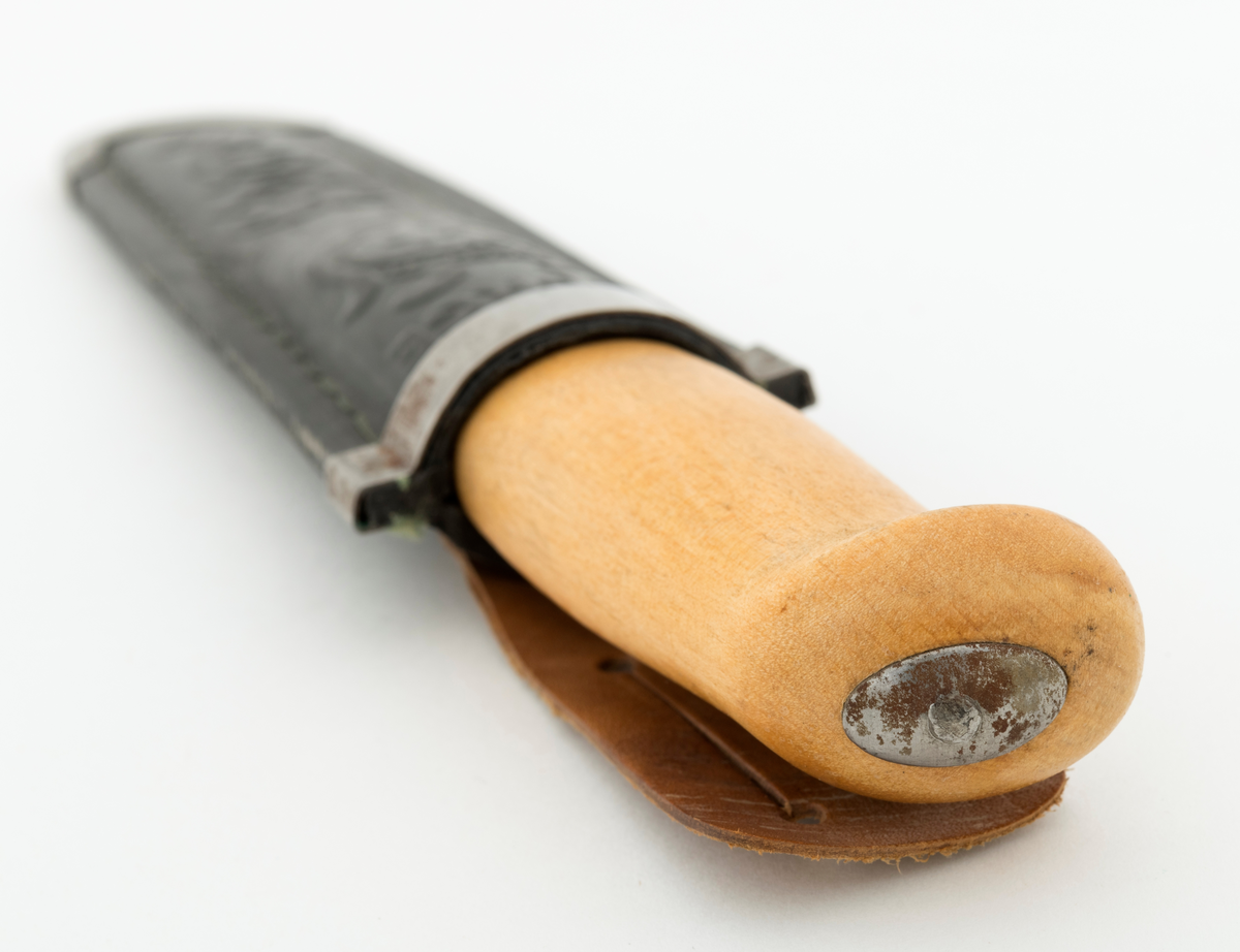 Tollekniv med slire. Denne kniven er fabrikkprodsert, og bladet minner om de populære svenske Mora-knivene, men er stemplet «B. KNUDSEN  TRONDHJEM  NORGE». Denne produsenten skal ha holdt det gående fra tidlig i 1890-åra til tidlig på 1960-tallet, med to generasjoner ledere - se fanene «Historikk» og «Opplysninger».

Kniven er 20,9 centimeter lang, målt fra bladspissen til den bakre enden av skaftet. Bladet utgjør 10 centimeter av denne lengden. Det er 2,2 centimeter bredt og 2,4 millimeter tjukt. Bladryggen er en aning konvekst buet og har avfasete sidekanter. Tangen på bladet er tappet gjennom den sentrale delen av et 10,7 centimeter langt treskaft. Skaftet har ovalt tverrsnitt og er i hovedsak konvekst i lengderetningen, men den bakre enden har en krok mot skaftbuken, en detalj som antakelig skulle fungere som anlegg for knivbrukerens lillefinger og dermed forebygge at redskapet glapp. Den bakre enden av den nevnte tangen er stuket mot ei oval stålskive på den noe skrå endeflata. 

Slira er lagd av to stykker svart plast som er sammenføyd ved hjelp av en kantsøm. Forbindelsen mellom disse to komponentene er dessuten forsterket med et «skeivt U-formet» stålbeslag i den nedre enden og et 1 centimeter bredt stålbånd på forsida av sliremunningen. Under dette bandet finner vi modellbetegnelsen «NORGE», og under dette navnet er det relieffdekor med et stilisert hjortedyr og akantusornamenter. Baksida av slira er glatt, men har informasjon om mønsterbeskyttelse i opphøyet relieff. På baksida av sliremunningen er det pånaglet et oppheng, en lysebrun lærlapp med to spalter, som enten kunne tres på et smalt belte eller eventuelt forankres i knapper i bukselinninga til brukeren.
