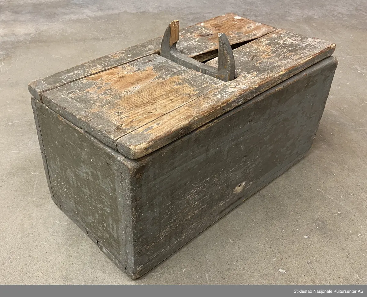 Todelt melkopp (kar) med hank og lokk, grågrønn farge. Svært slitt, sprukket, deler borte.