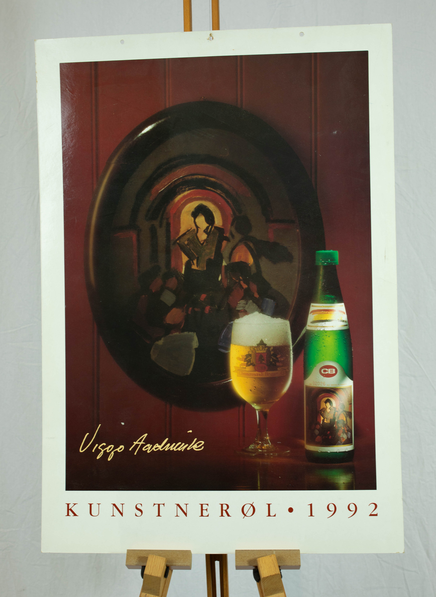 Et maleri på en vegg bak et glass med øl og en flaske med øl.