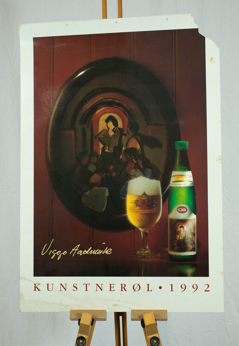 Et maleri på en vegg bak et glass med øl og en flaske med øl.