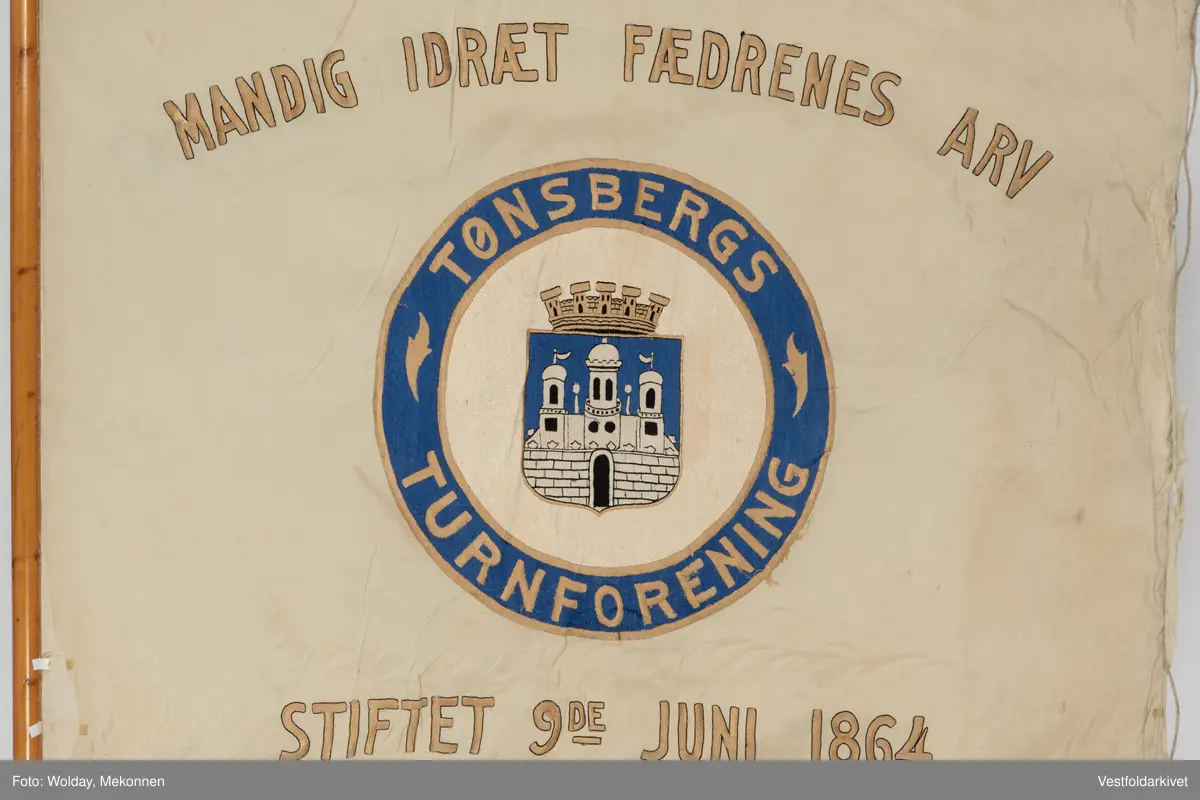 Lys silkefane med bemalt logo og tekst.