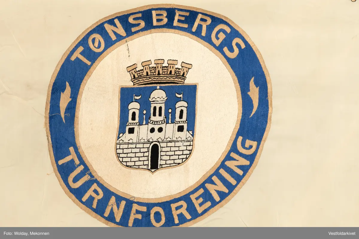 Lys silkefane med bemalt logo og tekst.