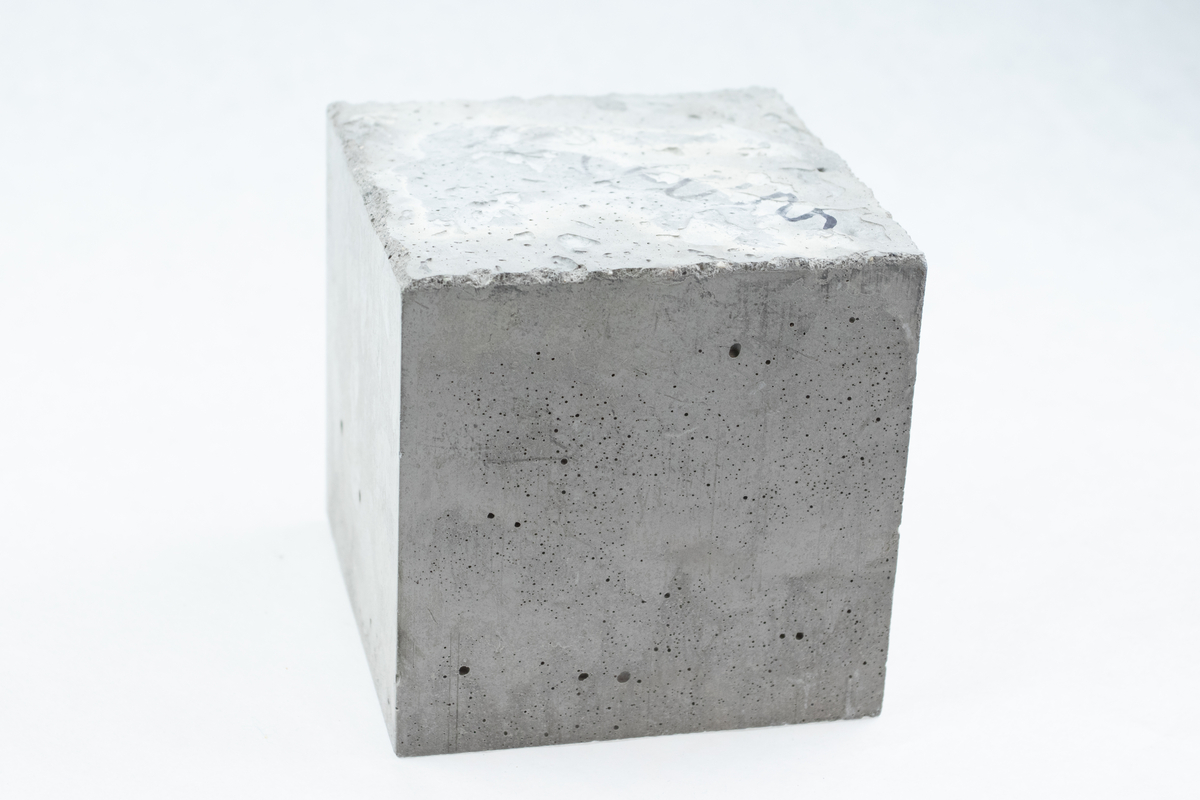 Kvadratisk trykktestet betongkloss. Den har fem glatte sider og en ruglete side.