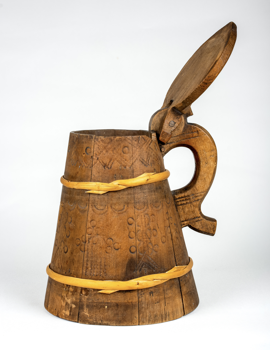Lagget drikkekanne med hank og lokk. Nyere gjorder. Utvendig svidekor på korpus, hank og lokk. Initialer og årstall skåret ut under bunnen: OHS // ANO 1784.