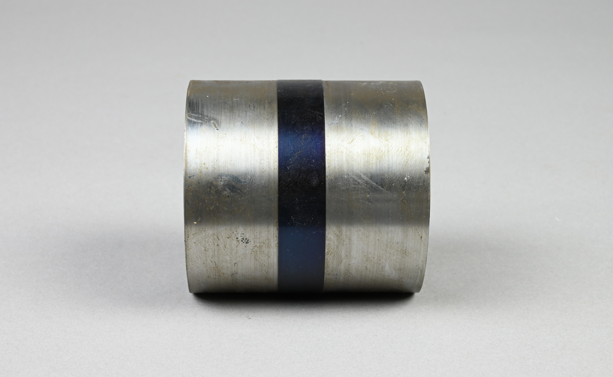 Prov på kallvalsat förzinkat bandstål. Två tillhörande lappar med notering: "Kallvalsat förzinkat bandstål. 66 x 0,575 mm. Martin 0,25 % C. Tillverkat vid Munkfors bruk, Uddeholms AB."