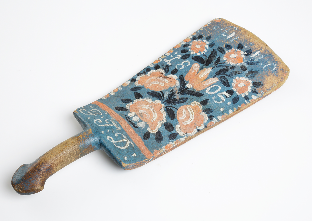 Blåmålat klappträ, dekorerat med blommor i orange, vitt och svart. Märkt Anno 1805 F.T.D.