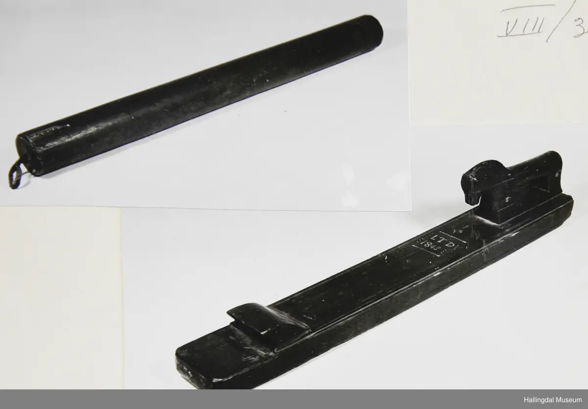 Den eine delen eit rektangulært trestykke, profilerte kantar. På bakre delen ein skoren hest. På framre delen eit handtak. Den andre delen er ein sylindrisk stokk, i eine enden ei lærhempe.