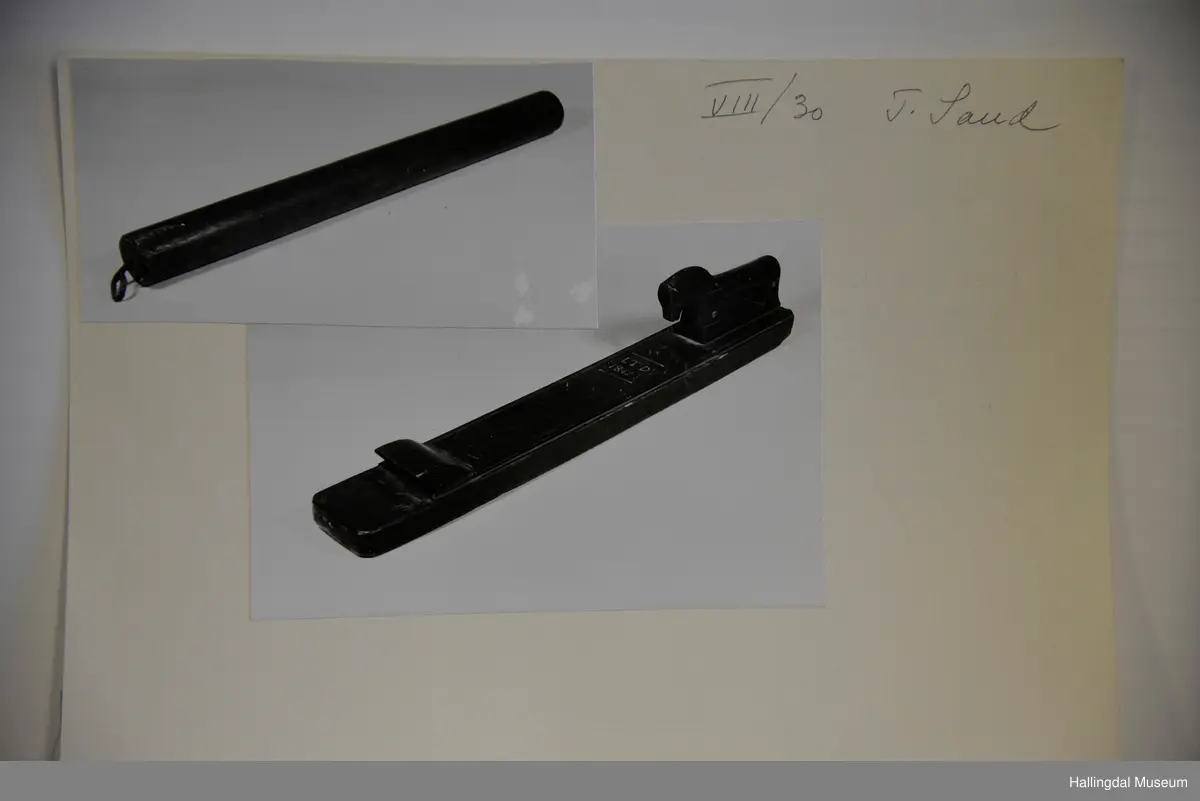 Den eine delen eit rektangulært trestykke, profilerte kantar. På bakre delen ein skoren hest. På framre delen eit handtak. Den andre delen er ein sylindrisk stokk, i eine enden ei lærhempe.