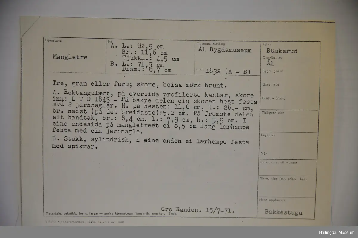 Den eine delen eit rektangulært trestykke, profilerte kantar. På bakre delen ein skoren hest. På framre delen eit handtak. Den andre delen er ein sylindrisk stokk, i eine enden ei lærhempe.