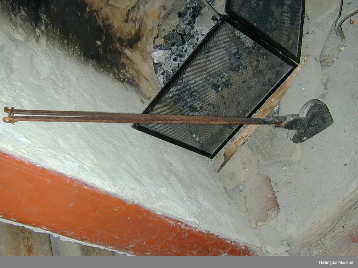 Kvar plate er eit hjarta. Endar i ei firkanta plate øvst, til denne er handtaket festa. Handtaka kryssar kvarandre like ovafor jarnet, festa til kvarandre med gjennomgåenade nagle.