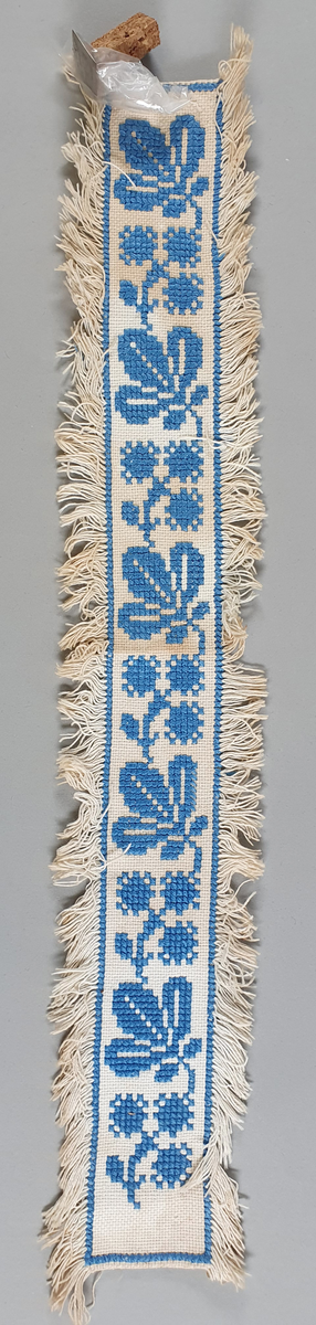 Ostebånd i bomull til 4-kilosost. Brodert i korssting på sultanstoff. Sølvstift følger med.